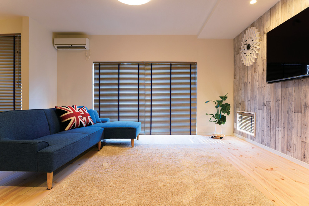 Imagen de salón para visitas abierto de estilo de casa de campo con paredes blancas, suelo de madera clara, televisor colgado en la pared, papel pintado y madera