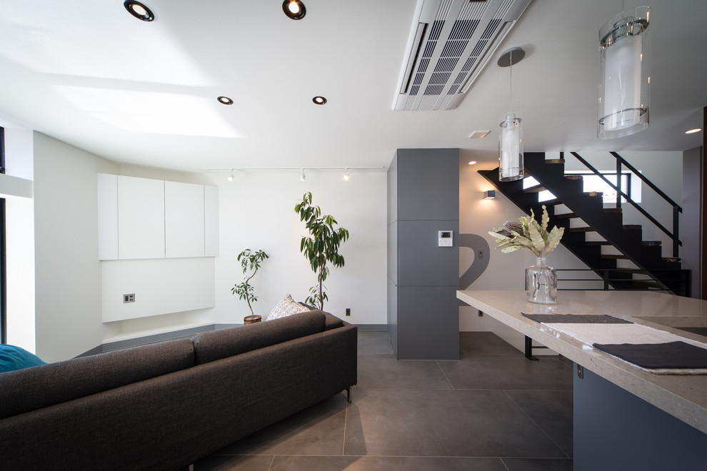 Idée de décoration pour un salon design avec un mur blanc et un sol gris.