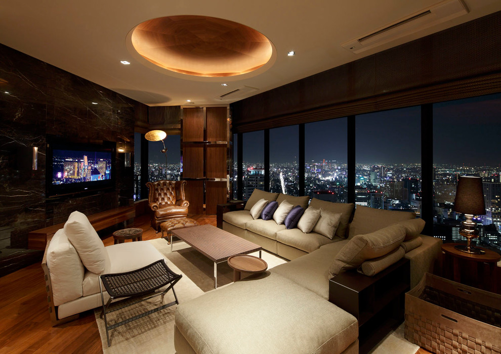 Foto di un soggiorno minimal con pavimento in legno massello medio e TV a parete