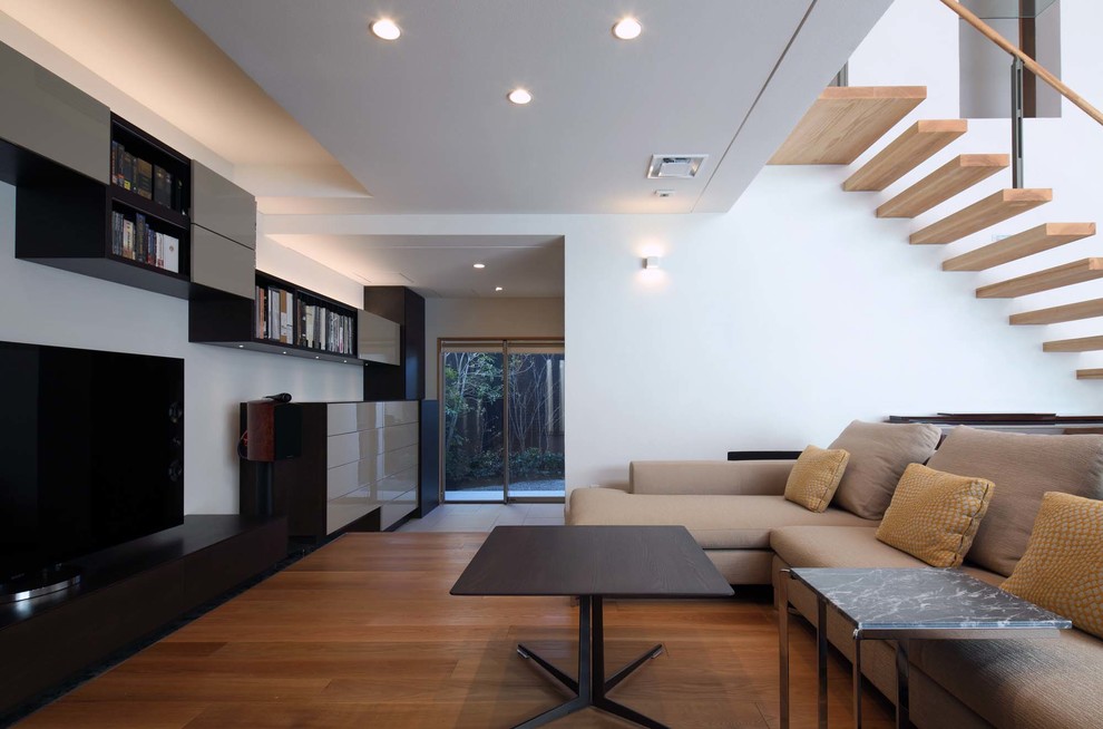 Modernes Wohnzimmer mit weißer Wandfarbe, braunem Holzboden und freistehendem TV in Kyoto