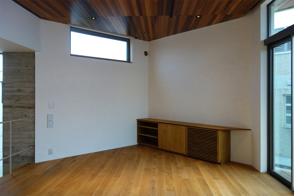 Inspiration för moderna allrum med öppen planlösning, med vita väggar, plywoodgolv och en fristående TV