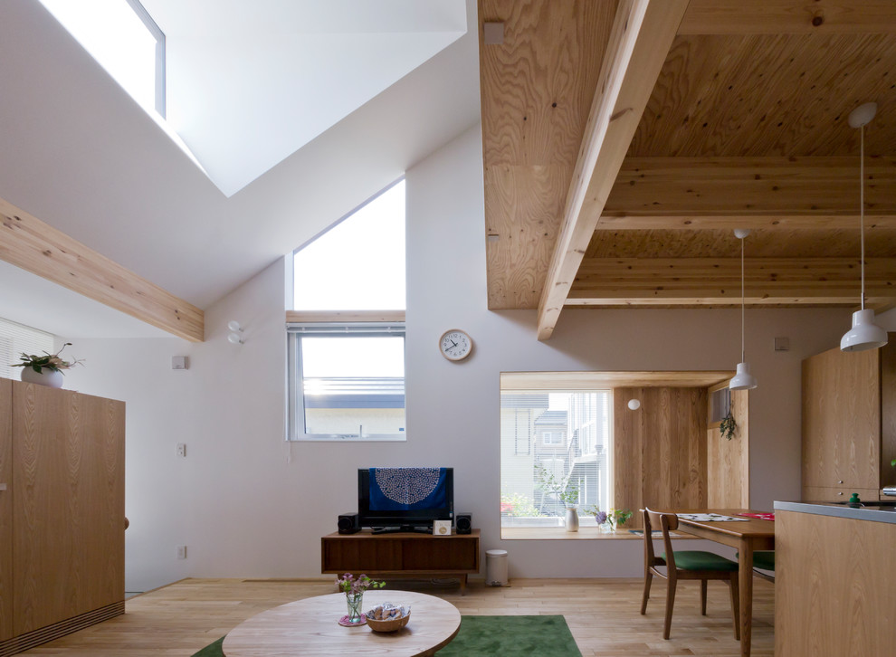 Ejemplo de salón abierto nórdico de tamaño medio con paredes blancas, suelo de madera clara y suelo beige