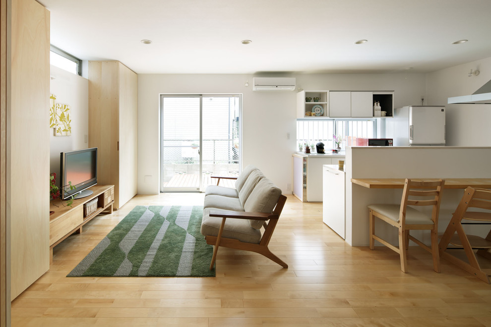 Mittelgroßes, Repräsentatives, Offenes Wohnzimmer ohne Kamin mit weißer Wandfarbe, hellem Holzboden und freistehendem TV in Tokio