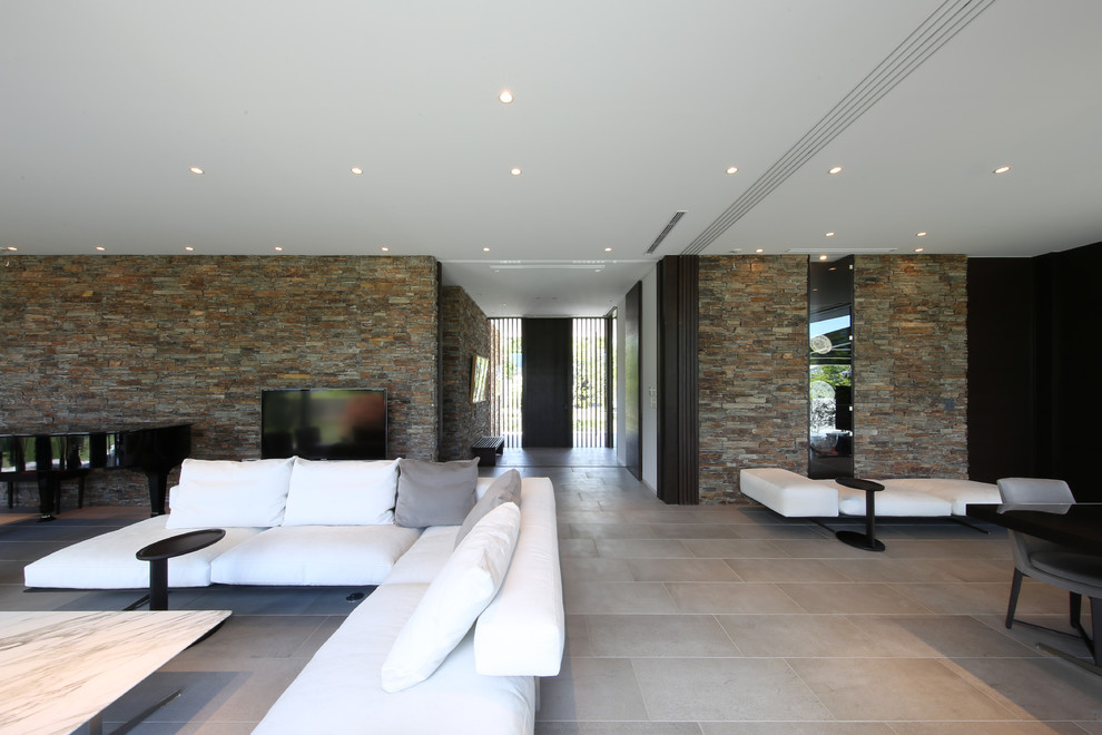 Foto di un soggiorno moderno aperto con TV autoportante, pavimento grigio e pareti multicolore