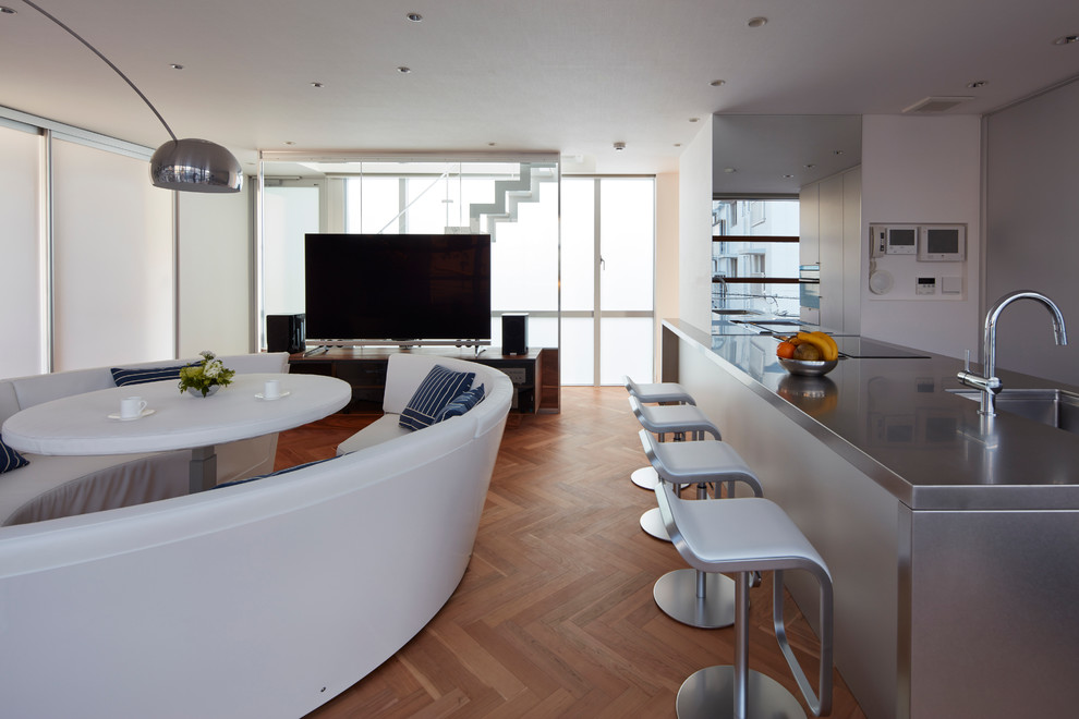 Esempio di un soggiorno moderno di medie dimensioni e chiuso con angolo bar, pareti nere, pavimento in legno massello medio e TV autoportante