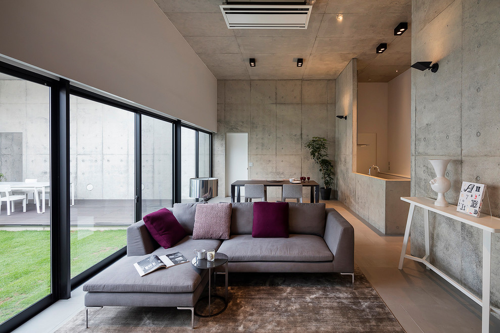 Cette photo montre un salon moderne ouvert avec un mur gris.