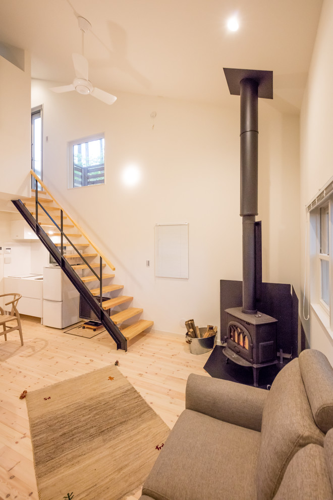 Landhausstil Wohnzimmer mit weißer Wandfarbe, hellem Holzboden und braunem Boden in Sonstige