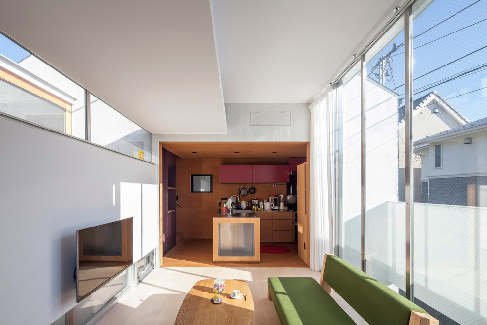 На фото: маленькая открытая гостиная комната в современном стиле с белыми стенами и телевизором на стене без камина для на участке и в саду с