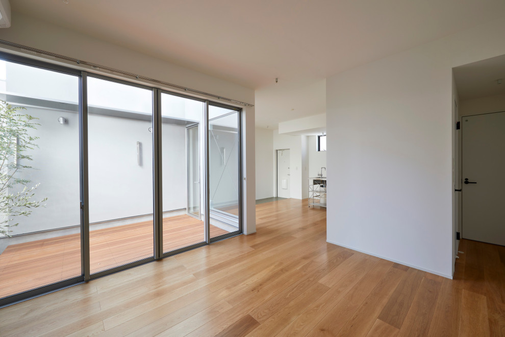 Immagine di un piccolo soggiorno minimalista aperto con pareti bianche, parquet chiaro, soffitto in carta da parati e carta da parati