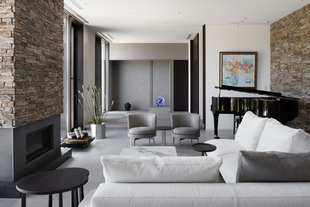 Contemporary living room in Other with multi-coloured walls, concrete flooring, grey floors and a standard fireplace.