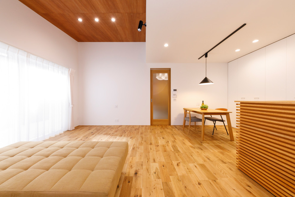 Inredning av ett mellanstort vardagsrum, med ett finrum, vita väggar, ljust trägolv och beiget golv