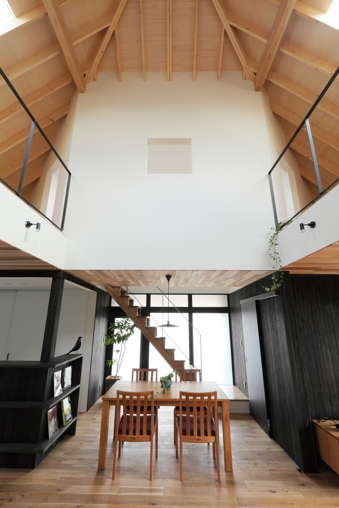 Exempel på ett mellanstort retro allrum med öppen planlösning, med svarta väggar, mellanmörkt trägolv, en väggmonterad TV och beiget golv