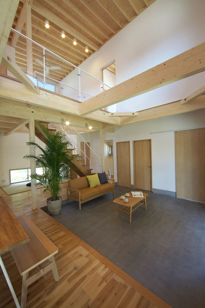 Идея дизайна: гостиная комната в восточном стиле с белыми стенами, бетонным полом и серым полом