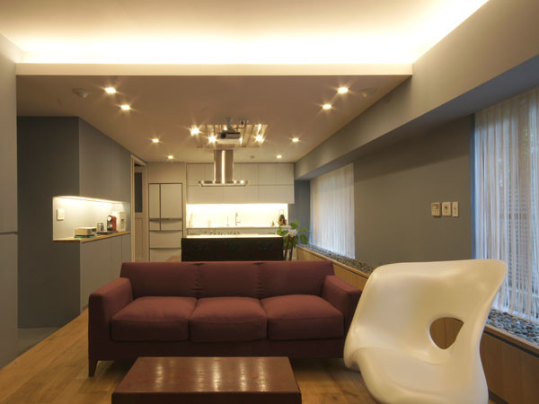 Cette image montre un salon minimaliste de taille moyenne et ouvert avec une salle de réception, aucun téléviseur, un mur gris, un sol en bois brun et aucune cheminée.
