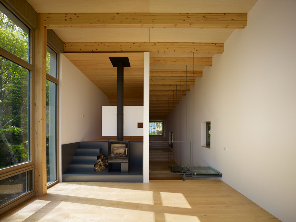 Idee per un soggiorno design con pareti bianche, parquet chiaro, stufa a legna e pavimento beige