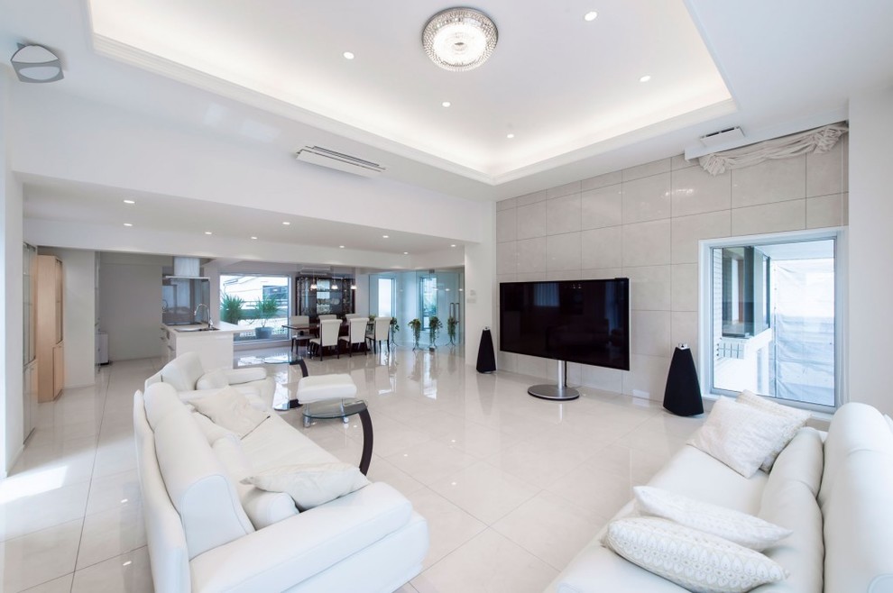 Стильный дизайн: открытая гостиная комната в стиле модернизм с белыми стенами, мраморным полом, отдельно стоящим телевизором и белым полом - последний тренд
