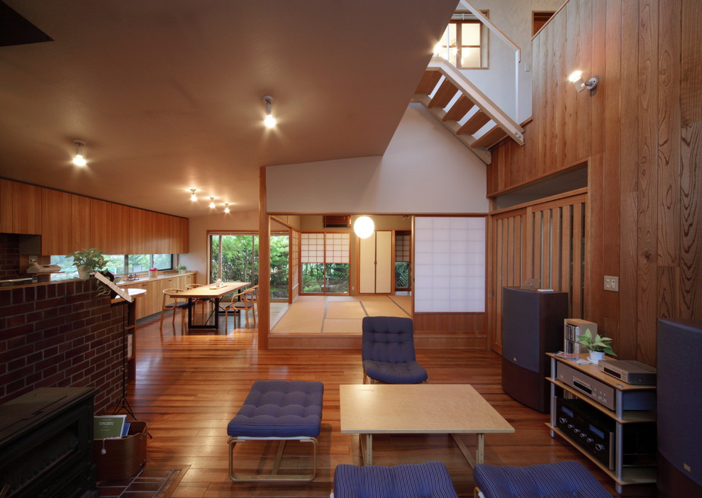 Идея дизайна: открытая гостиная комната в современном стиле с коричневыми стенами, паркетным полом среднего тона, коричневым полом и печью-буржуйкой
