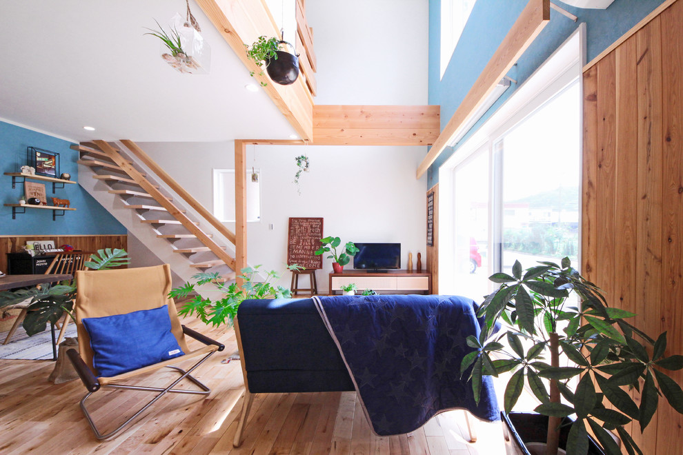 Источник вдохновения для домашнего уюта: открытая гостиная комната в скандинавском стиле с белыми стенами, светлым паркетным полом и отдельно стоящим телевизором