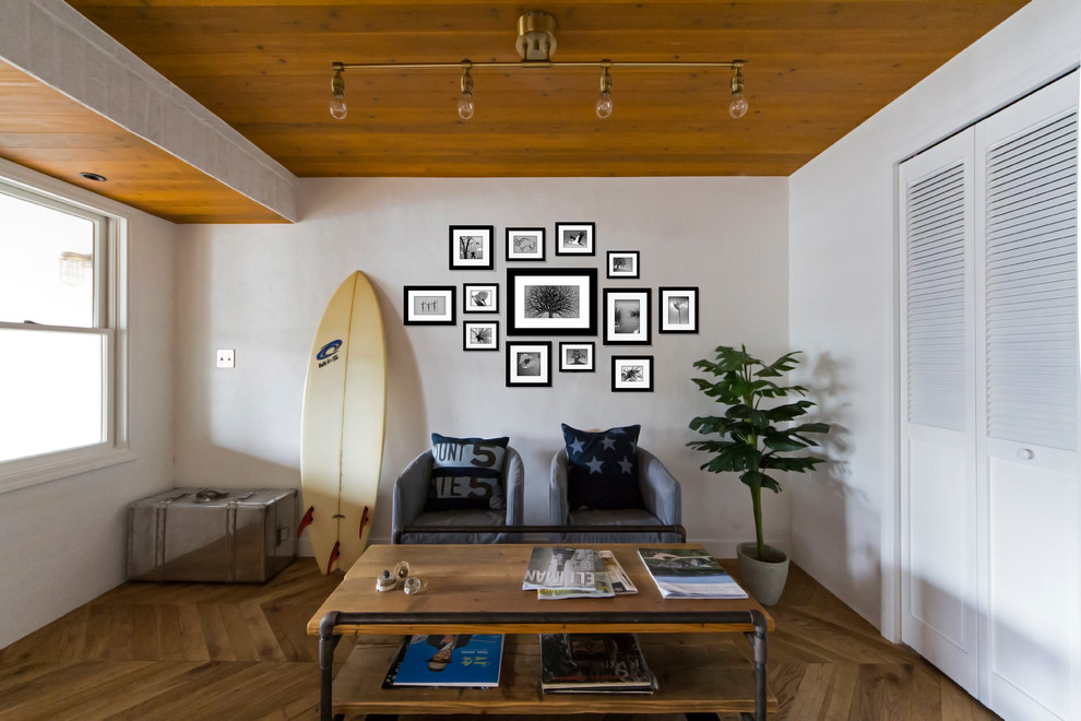 Пример оригинального дизайна: гостиная комната в морском стиле с белыми стенами, паркетным полом среднего тона и коричневым полом