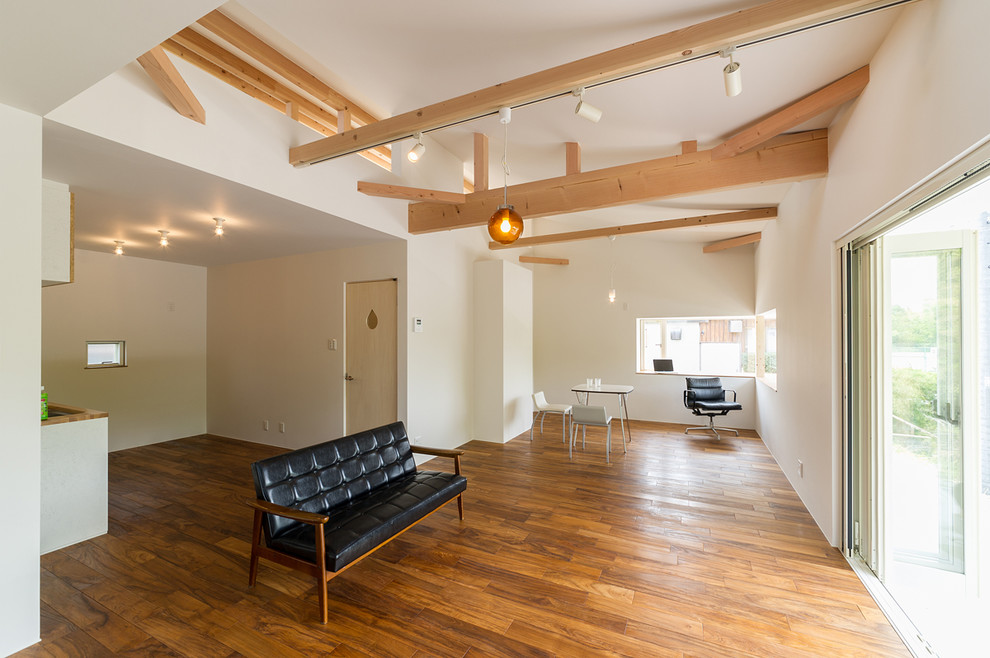 Cette photo montre un salon chic avec un mur blanc et un sol en bois brun.