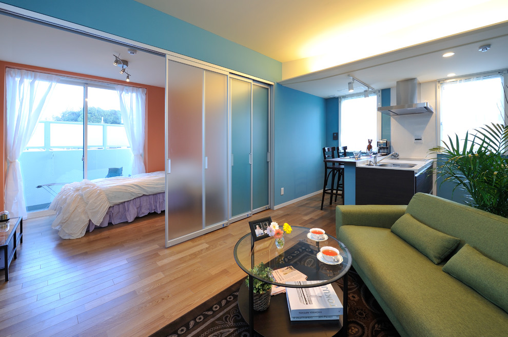 Источник вдохновения для домашнего уюта: маленькая открытая гостиная комната в современном стиле с домашним баром, синими стенами и полом из фанеры для на участке и в саду