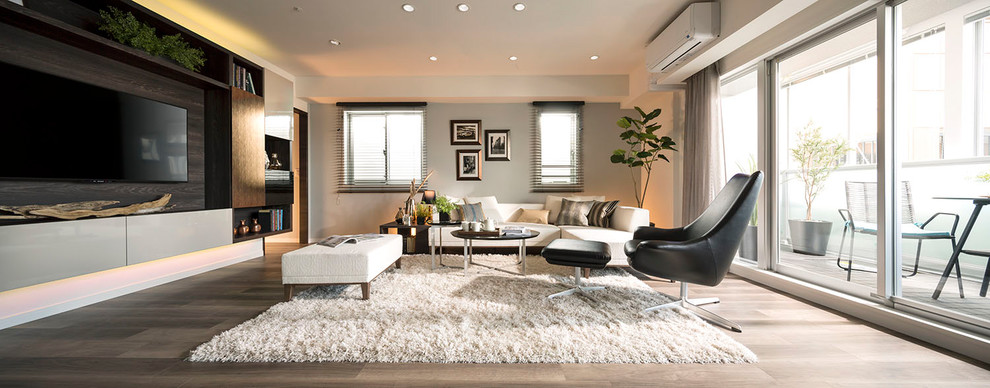 Modelo de salón actual con paredes grises, suelo de madera pintada, televisor colgado en la pared y suelo gris