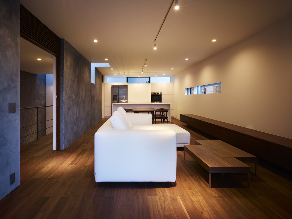 Inspiration för mellanstora moderna allrum med öppen planlösning, med vita väggar, plywoodgolv, en fristående TV och brunt golv