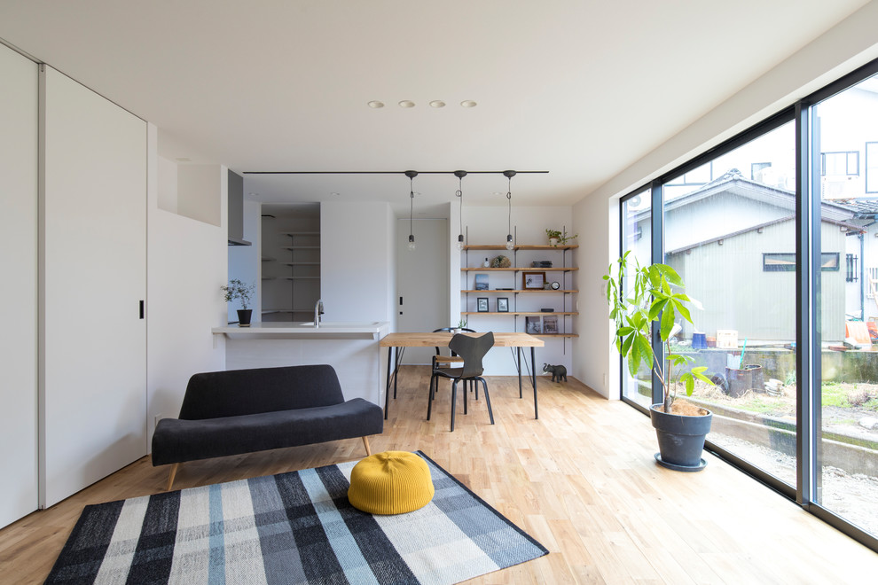 Идея дизайна: открытая гостиная комната в скандинавском стиле с белыми стенами, светлым паркетным полом и бежевым полом