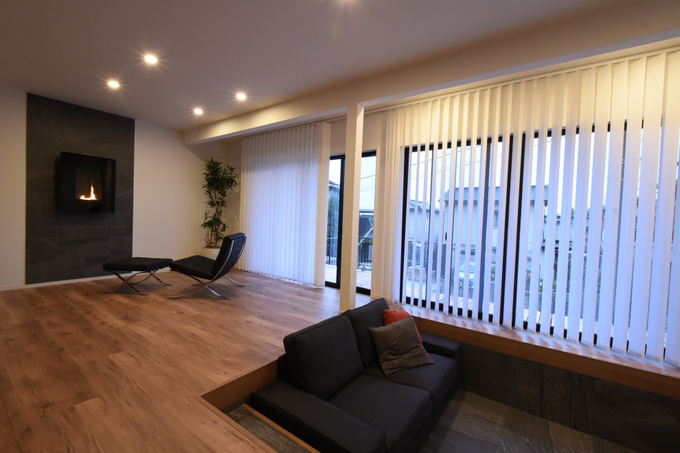 Пример оригинального дизайна: большая гостиная комната в стиле модернизм с белыми стенами, полом из фанеры, фасадом камина из плитки и коричневым полом