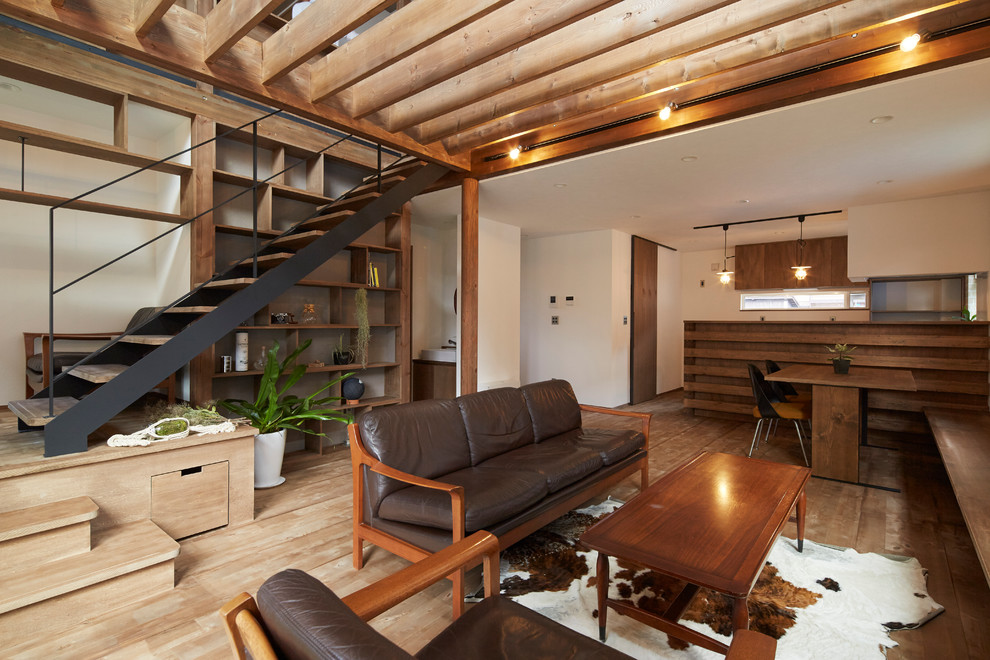 Idee per un soggiorno design aperto con pareti bianche e pavimento in legno massello medio