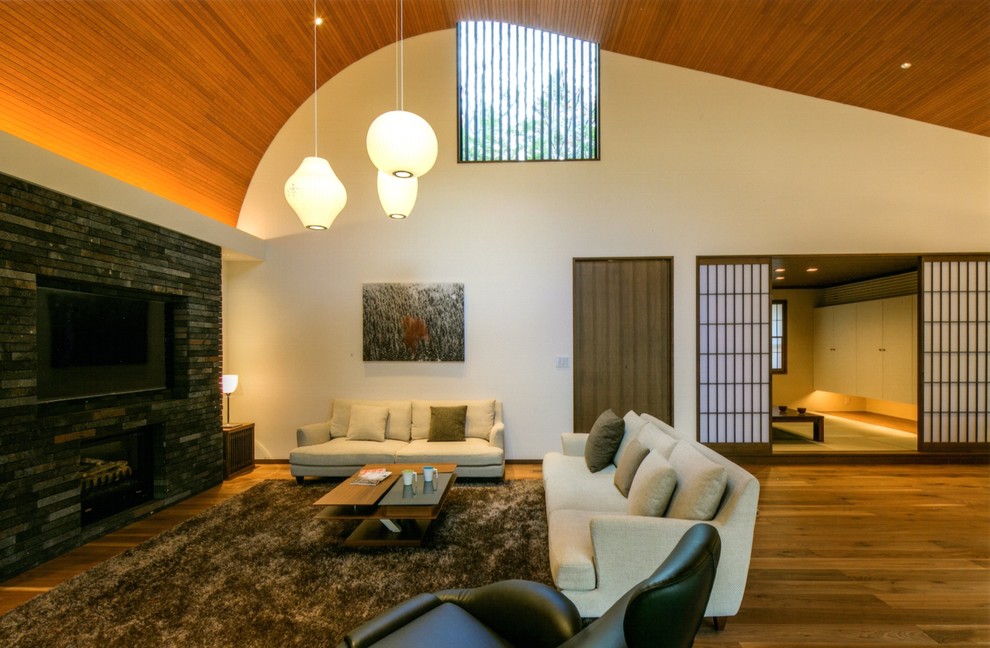 Foto de salón asiático de tamaño medio sin chimenea con paredes blancas, suelo de madera en tonos medios y televisor retractable