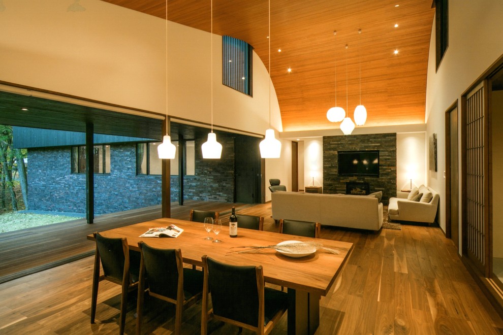 Idee per un soggiorno minimal aperto con pareti beige, pavimento in legno massello medio, parete attrezzata e nessun camino
