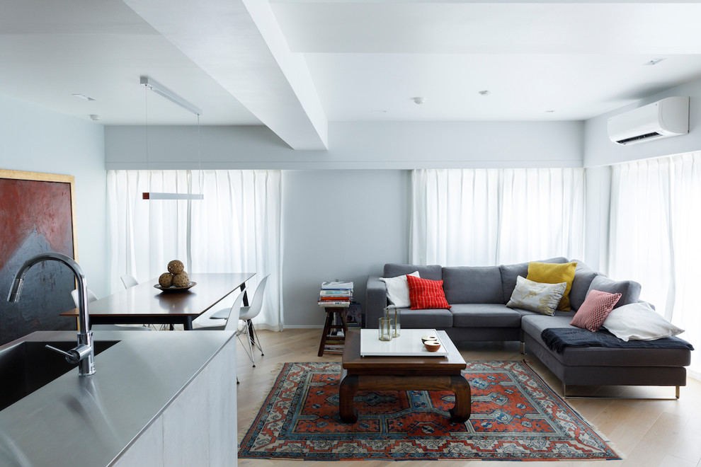 Esempio di un soggiorno moderno aperto con pareti bianche, parquet chiaro e pavimento beige