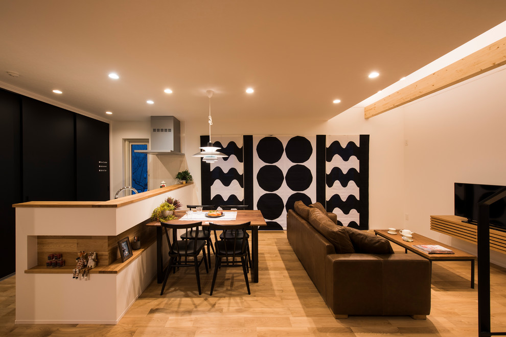Inspiration pour un salon nordique ouvert avec un mur blanc, un sol en bois brun, un téléviseur indépendant et un sol marron.