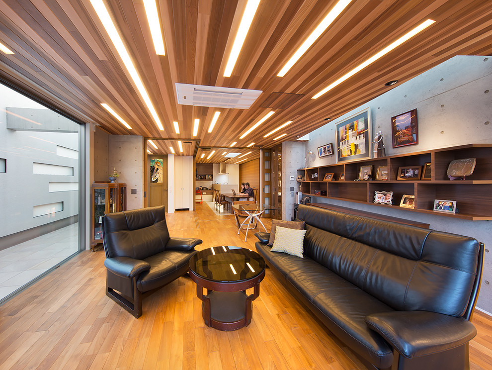 Offenes Asiatisches Wohnzimmer mit grauer Wandfarbe, braunem Holzboden und braunem Boden in Fukuoka