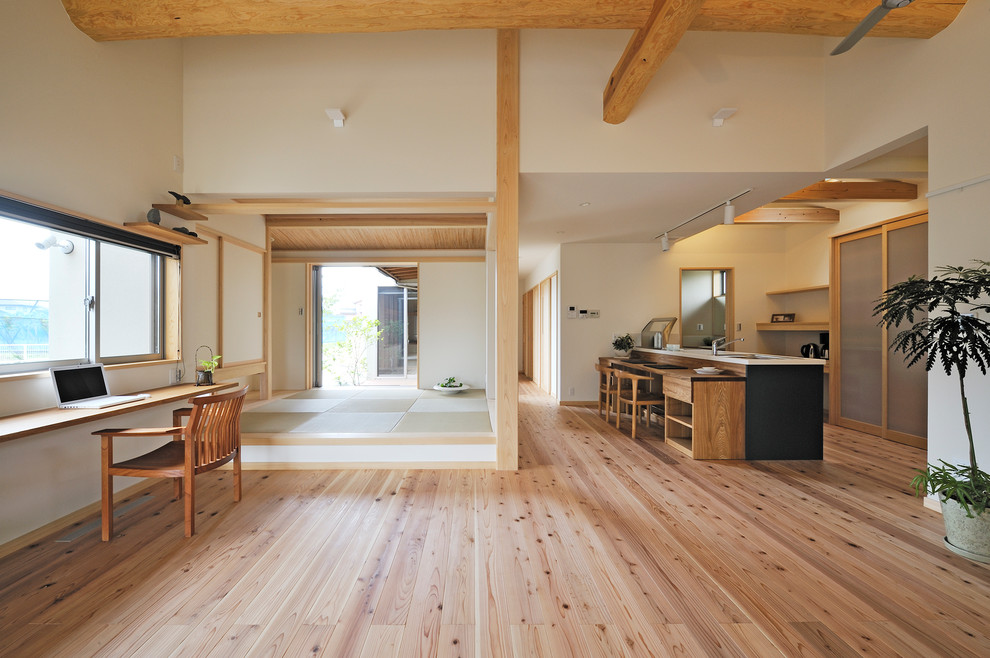 Offenes Asiatisches Wohnzimmer mit beiger Wandfarbe, hellem Holzboden, TV-Wand und beigem Boden in Sonstige