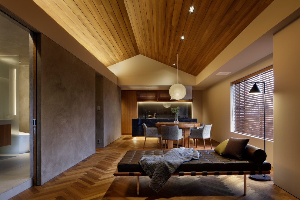 Diseño de salón abierto actual de tamaño medio con suelo de contrachapado, suelo marrón y paredes marrones