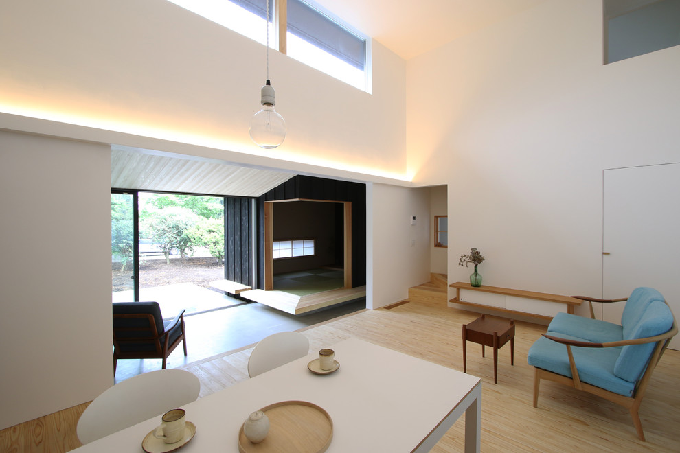 Imagen de salón abierto moderno de tamaño medio con chimenea de esquina, paredes blancas, suelo de madera clara y suelo beige