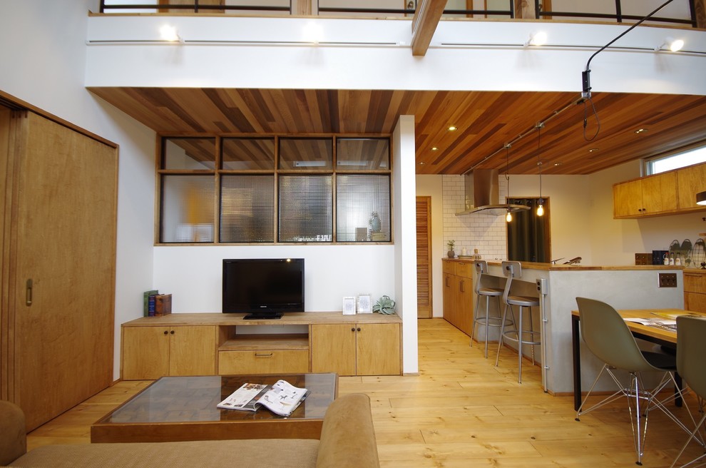 Пример оригинального дизайна: открытая гостиная комната в восточном стиле с белыми стенами, паркетным полом среднего тона, отдельно стоящим телевизором и коричневым полом