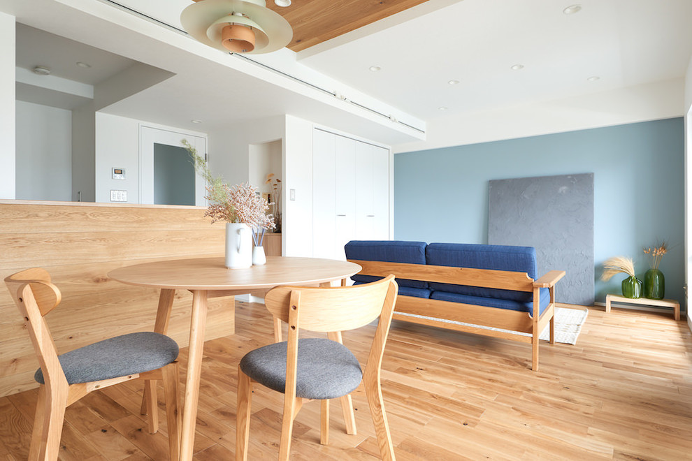 This is an example of a scandi open plan living room in Other with blue walls, light hardwood flooring and beige floors.