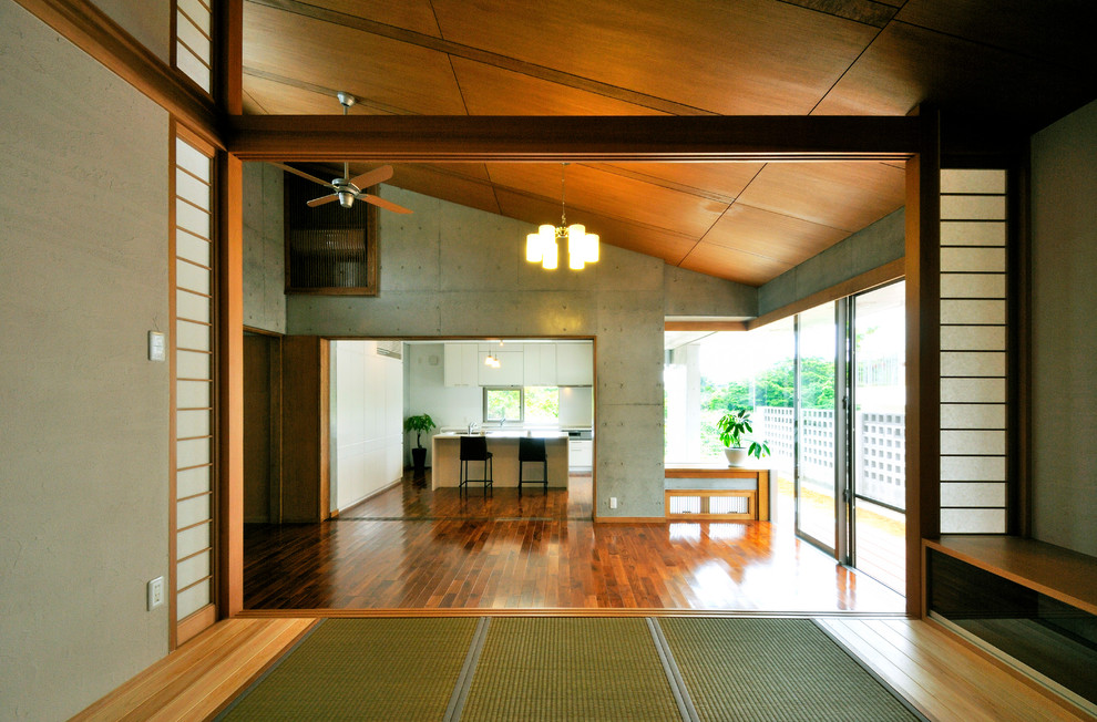Cette photo montre un salon asiatique avec un mur gris, un sol en bois brun et un sol marron.