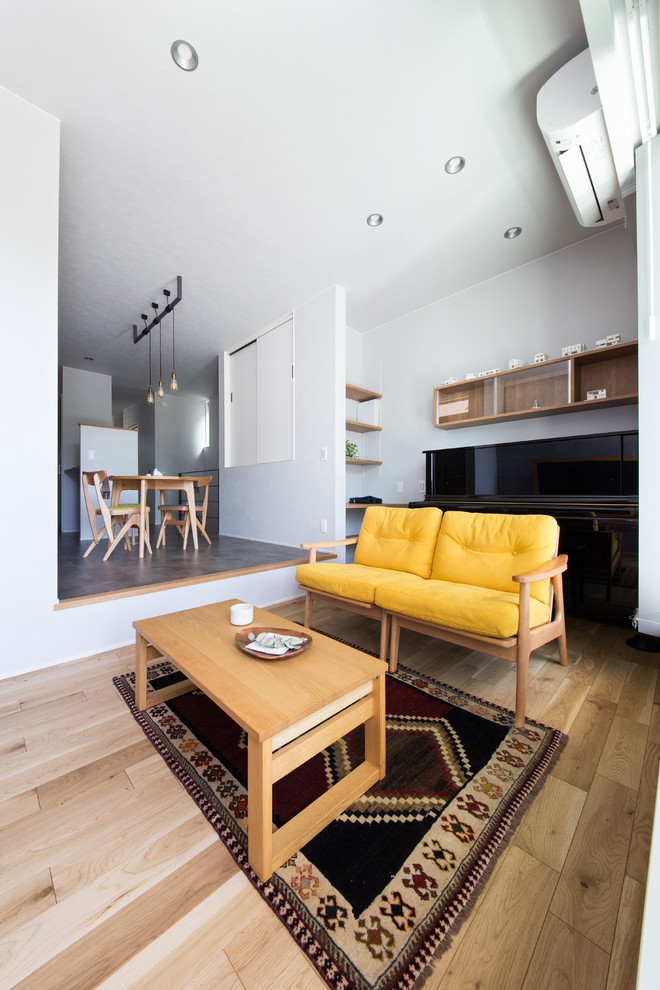 Diseño de salón abierto moderno sin chimenea con paredes grises, suelo de contrachapado y suelo marrón