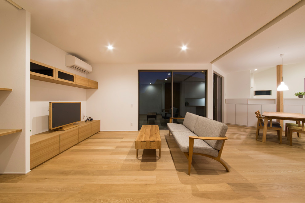 Свежая идея для дизайна: открытая гостиная комната в восточном стиле с белыми стенами, паркетным полом среднего тона и коричневым полом - отличное фото интерьера