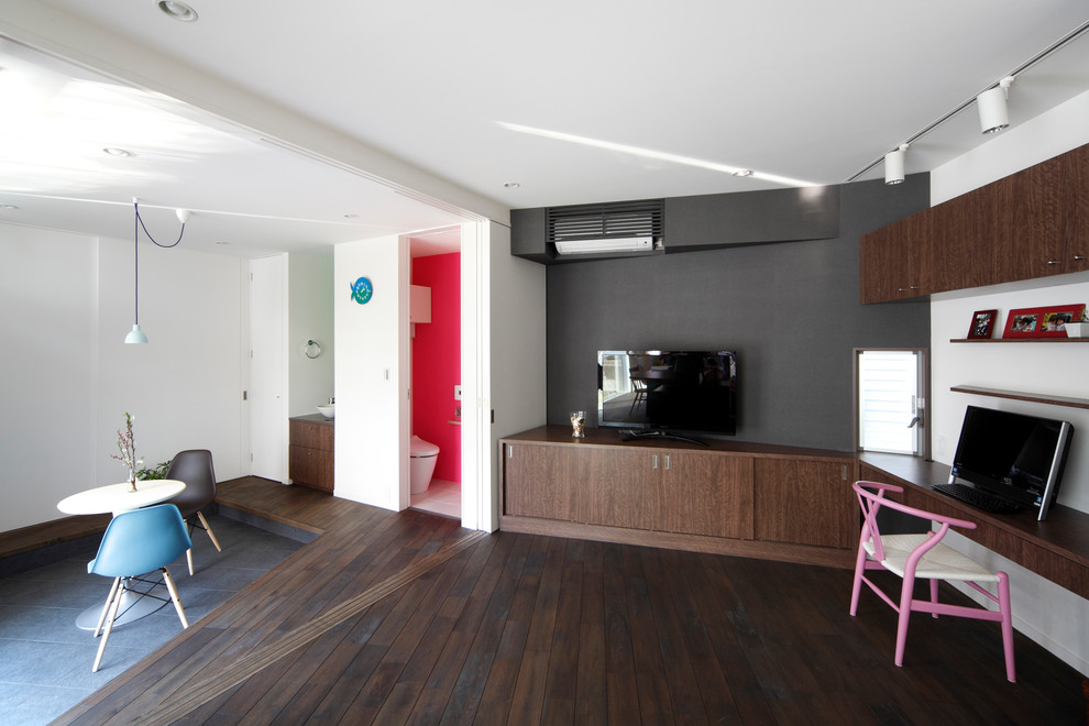 Источник вдохновения для домашнего уюта: гостиная комната в современном стиле с разноцветными стенами, темным паркетным полом, отдельно стоящим телевизором и коричневым полом