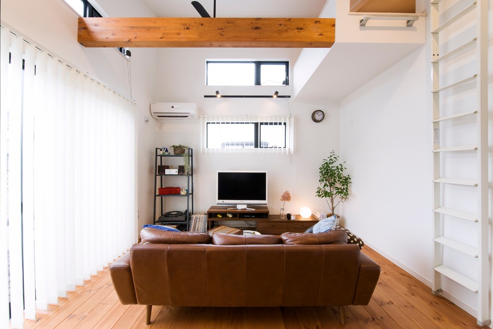 Skandinavisches Wohnzimmer ohne Kamin mit weißer Wandfarbe und freistehendem TV in Sonstige