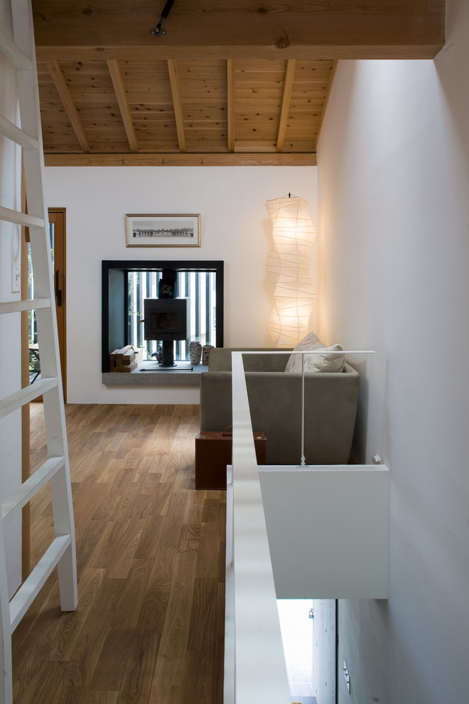 Diseño de salón contemporáneo con paredes blancas, suelo de madera oscura y estufa de leña