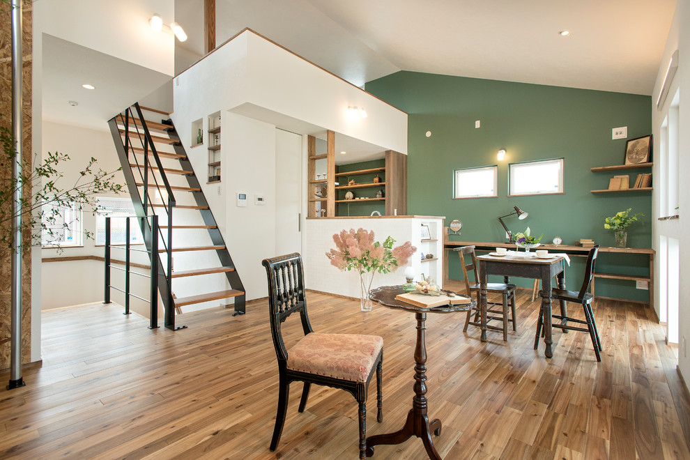 Immagine di un soggiorno etnico aperto con pareti verdi, pavimento in legno massello medio e pavimento marrone