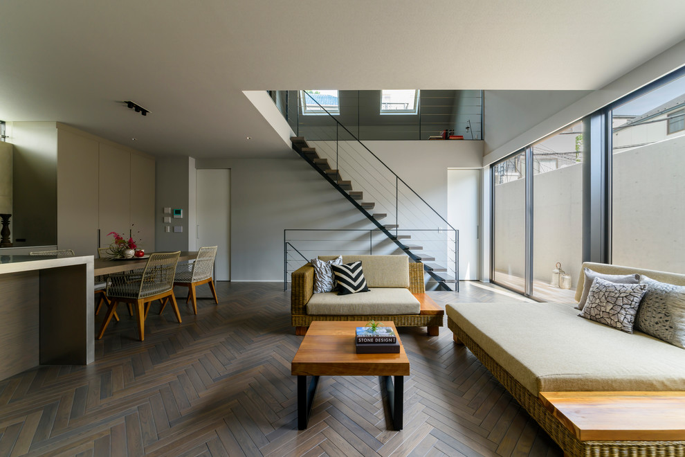 Cette photo montre un salon moderne ouvert avec un mur blanc, parquet peint et un sol gris.