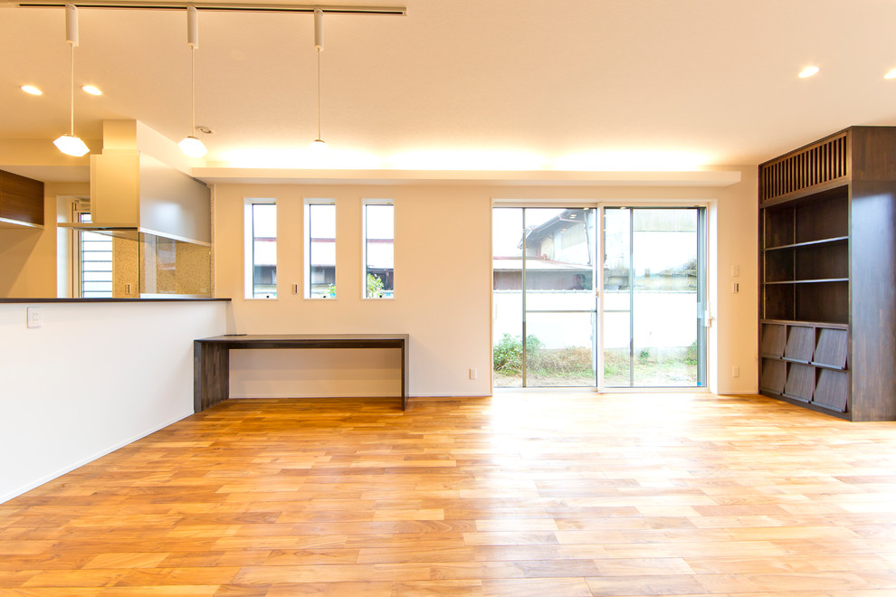 Exempel på ett mellanstort modernt allrum med öppen planlösning, med ett finrum, beige väggar, ljust trägolv, en fristående TV och orange golv