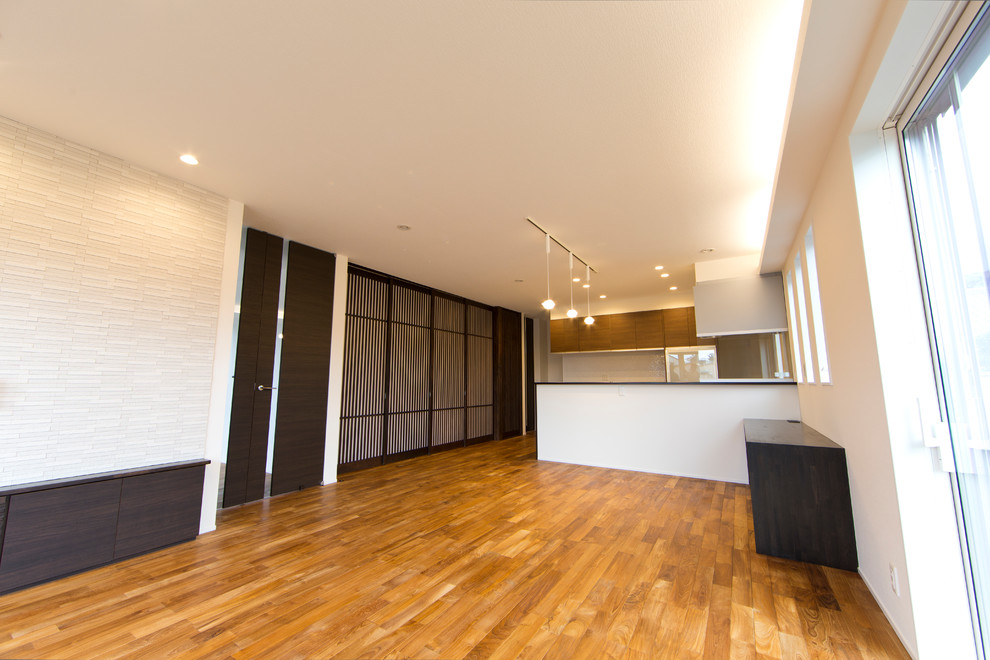 Mittelgroßes, Repräsentatives, Offenes Modernes Wohnzimmer mit beiger Wandfarbe, hellem Holzboden, freistehendem TV und orangem Boden in Sonstige